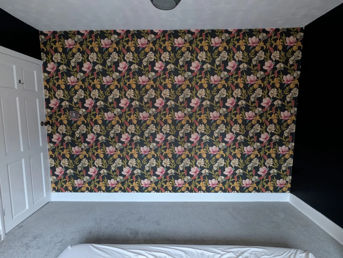 Finished dark floral bedroom feature wall beside the white door
