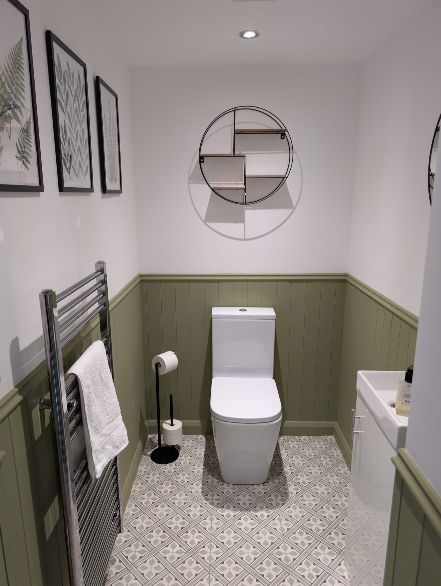 Finished cloakroom with sage green painted panelling, pale walls and patterned flooring