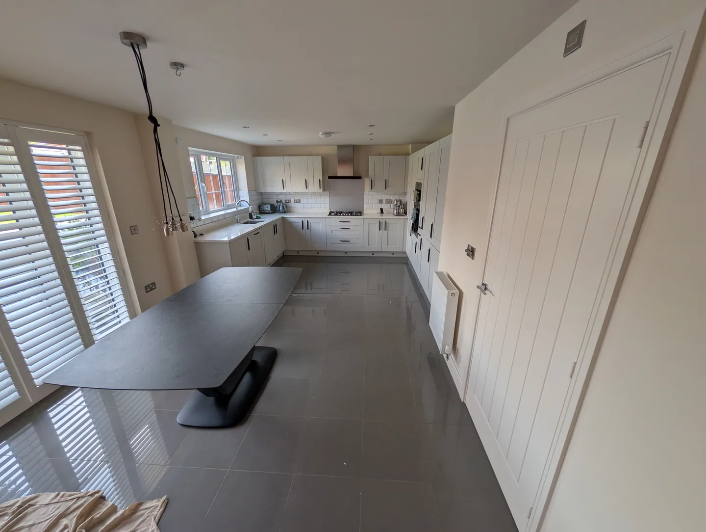 Kitchen with freshly painted light walls and a terracotta accent at the far end
