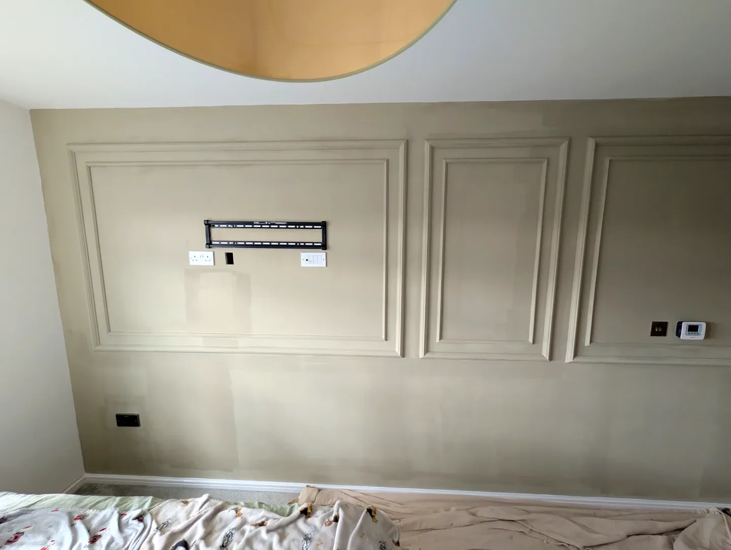 Muted green painted decorative wall mouldings in a bedroom